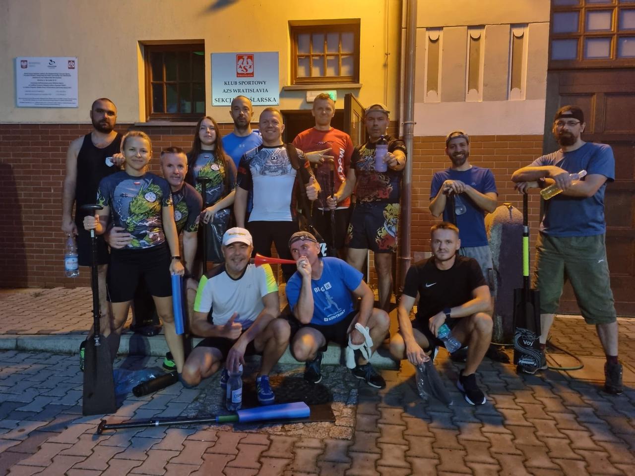 Członkowie KTW z wiosłami wieczorem przed budynkiem przystani AZS Wratislavia, sekcja wioślarska