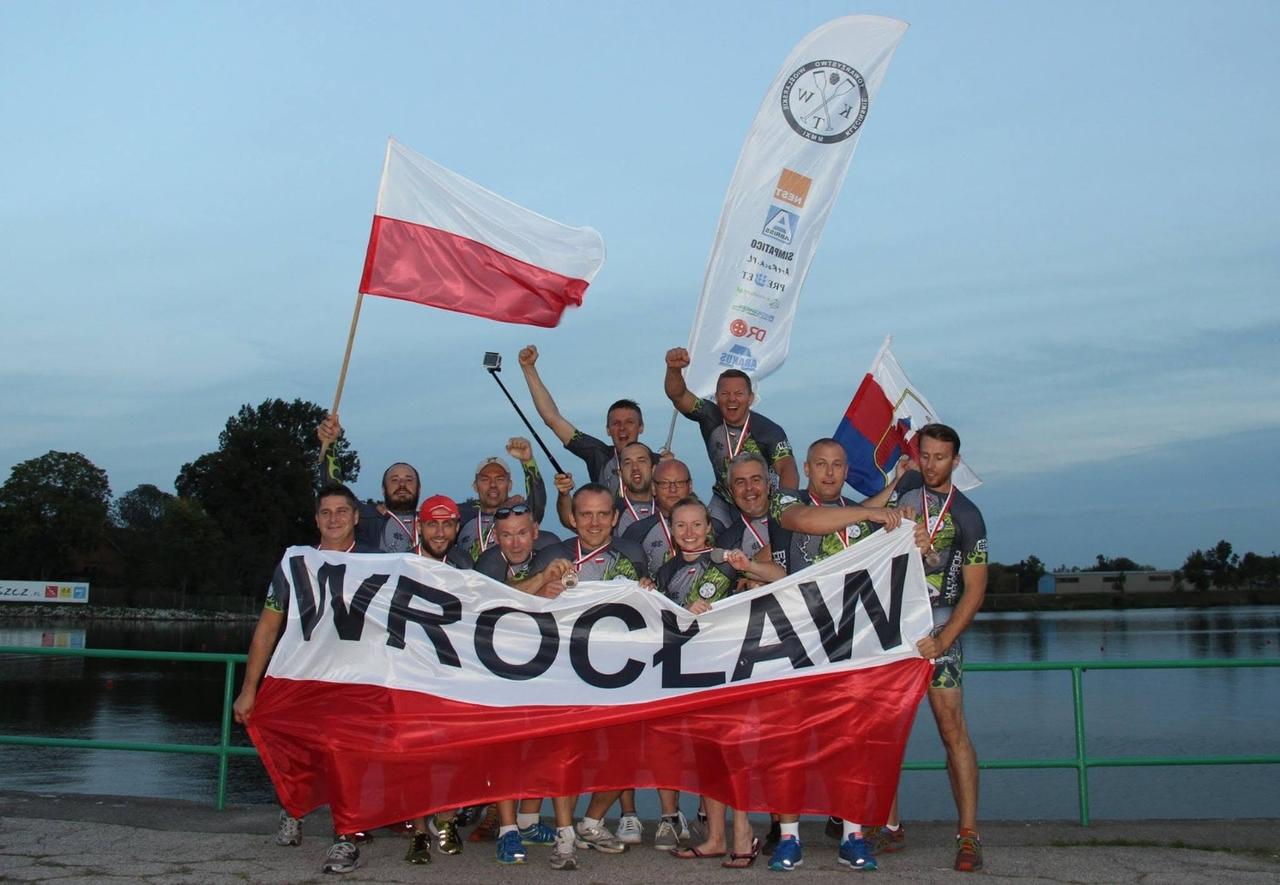 Drużyna KTW z medalami, biało-czerwonym transparentem WROCŁAW i flagami nad kanałem w Bydgoszczy o zmierzchu, Mistrzostwa Polski 2016